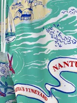 Short de baño celeste con estampado de motivos náuticos en rojo, blanco y azul.