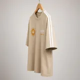Remera de algodón color beige con diseño de sol bordado y texto en el frente. Presenta dos franjas blancas laterales en las mangas y un corte holgado.