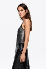 Top sin mangas de corte ajustado con escote redondo, confeccionado en tejido con lentejuelas brillantes y vivos en contraste en el cuello y las sisas.