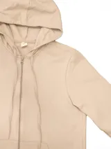 Campera deportiva unisex color beige, confeccionada en algodón con felpa, con capucha, cierre frontal y bolsillo tipo canguro.