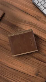 Billetera de cuero marrón con vivos combinados en los bordes superior e inferior. El interior cuenta con doble repartición para billetes, visor, tarjeteros y bolsillos.