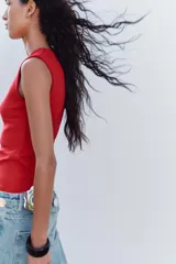 Top blanco de manga sisa con cuello redondo y corte ajustado al cuerpo.