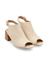 Sandalia peep toe de cuero color crema, con taco ancho de madera de 6 cm, tira ajustable con hebilla metálica dorada en el talón y suela de caucho antideslizante.