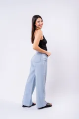 Pantalón de jean celeste de tiro alto, corte wide leg y largo completo. Presenta costuras decorativas en contraste a lo largo de las piernas.