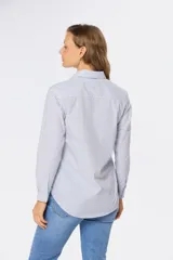 Camisa de manga larga con cuello clásico y corte recto, a rayas verticales rosas y blancas.