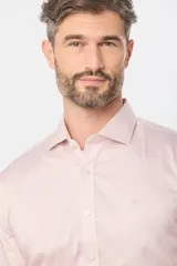 Camisa de vestir blanca de corte clásico, con mangas largas, cuello camisero y cierre frontal de botones.