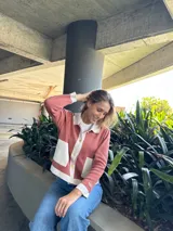 Chaqueta color salmón con detalles en blanco, de corte recto y manga larga.