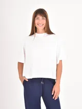 Remera de corte boxy y holgado, con cuello redondo y mangas cortas, confeccionada en tejido de algodón liso.