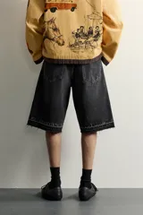 Bermuda de denim de algodón con efecto lavado desgastado en tonos marrones y azules. Tiene tiro medio, diseño de cinco bolsillos, pierna recta de corte holgado y bajo con acabado irregular. Cuenta con cierre frontal de cremallera y botón metálico.