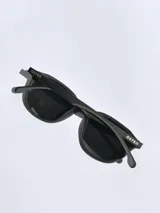 Lentes de sol Osten modelo Maui, con armazón negro de diseño redondeado y detalles en color naranja en las patillas. Cuentan con cristales polarizados con protección UV 400.
