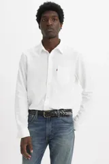 Camisa de lino blanca con cuello clásico, cierre frontal de botones, manga larga y un bolsillo aplicado en el pecho con etiqueta roja de la marca.