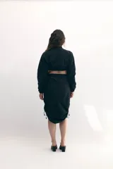 Campera cropped negra de tela técnica, con cuello alto, mangas murciélago y cierre frontal al tono.