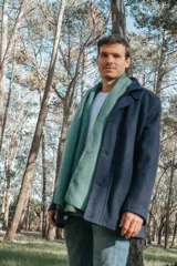 Campera azul marino de paño con cuello alto, cierre frontal con botones y bolsillos laterales.