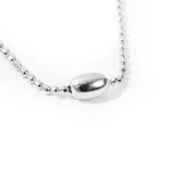 Collar plateado con cadena de bolitas y dije central ovalado.