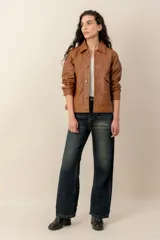 Campera de cuero marrón, con cuello camisero, cierre frontal con botones metálicos y bolsillos frontales.