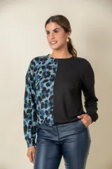 Buzo de manga larga con cuello redondo, combinado en dos tonos: negro liso en la mitad derecha y estampado animal print blanco y negro en la mitad izquierda.