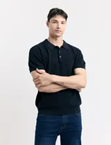 Chomba de punto color azul marino, con cuello polo y mangas cortas.