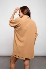 Camisa color verde claro, de corte holgado, con cuello clásico, cierre frontal con botones y mangas cortas. Incluye short haciendo juego con cintura elastizada y cordón de ajuste.