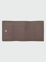 Billetera compacta Longchamp modelo Le Foulonné, confeccionada en cuero granulado color marrón topo, con diseño plegable y cierre de botón a presión.