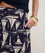 Pollera midi de corte evasé, con cintura elástica, confeccionada en viscolino con estampado figurativo de veleros en azul marino y blanco.