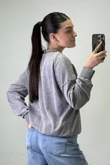 Buzo de cuello redondo con efecto acid wash, de corte holgado y mangas largas con puños elásticos.