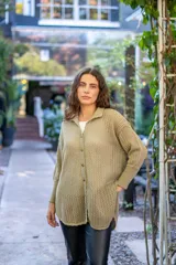 Camisa de punto calado en color beige con hilo de lurex. Presenta una silueta oversize, cuello camisero clásico, mangas 3/4 ligeramente abullonadas y cierre frontal con botones metálicos.