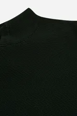 Sweater de punto color verde oscuro, con cuello alto tipo polo y diseño de manga larga. Presenta una textura tejida y un pequeño detalle de etiqueta en el lateral inferior.
