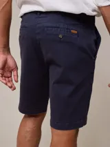 Bermuda azul marino de gabardina, corte recto, con bolsillos laterales y traseros.
