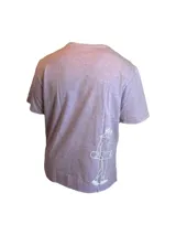 Remera color beige de algodón premium, manga corta y cuello redondo. Presenta un estampado circular en el centro del pecho con un diseño abstracto en tonos grises.