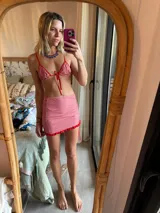 Conjunto de bikini con estampado a cuadros rojos y blancos, compuesto por un corpiño triangular con tirantes finos y una minifalda con volados en el ruedo.