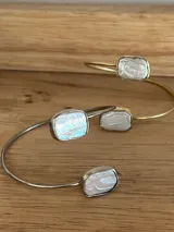 Brazalete abierto hecho a mano en bronce con extremos decorados con perlas de río naturales.