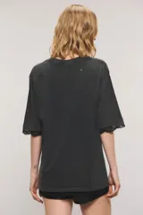 Remera oversize de jersey de algodón en color blanco, con cuello redondo, mangas cortas y largo a la cadera. Presenta estampa frontal con la inscripción "Gypsy Lover", detalles de roturas y apliques de puntilla en las mangas y el ruedo.