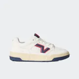 Championes Vans modelo Upland de estilo retro inspirado en los años 90. Presentan una base de ante color blanco con detalles en azul marino y rojo en el logotipo lateral en forma de V. Cuentan con una suela cupsole gruesa en tono crema, cordones anchos y cuello acolchado para mayor comodidad.