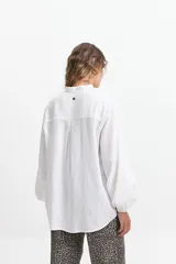 Camisa de manga larga color blanco, con cuello mao y corte holgado. Confeccionada en tejido tipo lino.