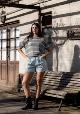 Remera de hilo tejido a rayas horizontales color beige y negro, de mangas cortas y corte suelto.