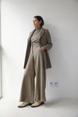 Saco corto entallado de lana fina, con cuello solapa, manga larga y cierre frontal con botones. Presenta un diseño clásico con textura de espiga en tonos tierra.