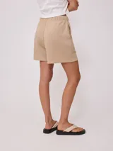 Short de tiro alto confeccionado en tejido de algodón y poliéster, con cintura elástica y bordado pequeño en la parte inferior.