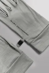 Guantes de running negros, ligeros y ajustados, confeccionados en tejido técnico con mezcla de lana. Cuentan con función táctil en los dedos y un enganche lateral de seguridad para unirlos.