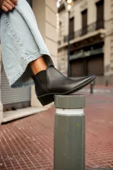 Botas tipo chelsea de cuero negro, con elásticos laterales y taco bajo cuadrado.