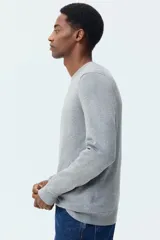 Buzo de punto fino con cuello redondo y diseño de corte estándar. Presenta terminaciones acanaladas en el cuello, los puños y el ruedo.