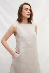 Vestido midi color beige de lino, sin mangas y con escote redondo.