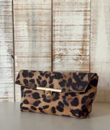 Sobre de mano con diseño de estampado animal print de leopardo, con cierre frontal metálico en tono dorado.