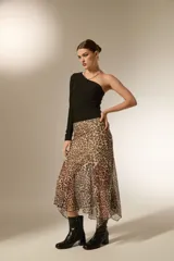 Falda midi de corte irregular con estampado animal print de leopardo, confeccionada en tejido semitransparente.