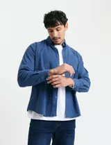Camisa de franela lisa con cuello button-down, manga larga, bolsillo frontal y botones al tono.