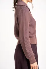 Cardigan tejido de algodón en color marrón, con cuello solapa, cierre frontal completo con cremallera y diseño de canalé ancho.
