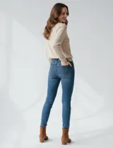 Buzo color beige con cuello redondo y lentejuelas doradas bordadas en la parte superior.