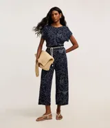 Pantalón recto color azul marino con estampa de follaje en blanco, confeccionado en viscosa con textura acanalada. Incluye trabillas en la cintura y un cinturón tipo cuerda.