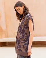 Chaleco oversize de punto con hilo lúrex, cuello en V y cierre frontal de botones. Presenta un estampado jacquard con efecto marmolado en tonos marrones y morados, bolsillos frontales aplicados y ribetes en contraste en el escote, sisas y dobladillo.