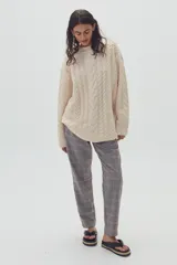 Sweater beige de lana y alpaca con diseño de ochos, cuello redondo y corte oversized.