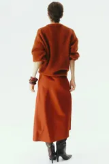 Pollera midi de tejido satinado color terracota, con corte fluido, elástico oculto en la cintura y leve vuelo en el bajo.